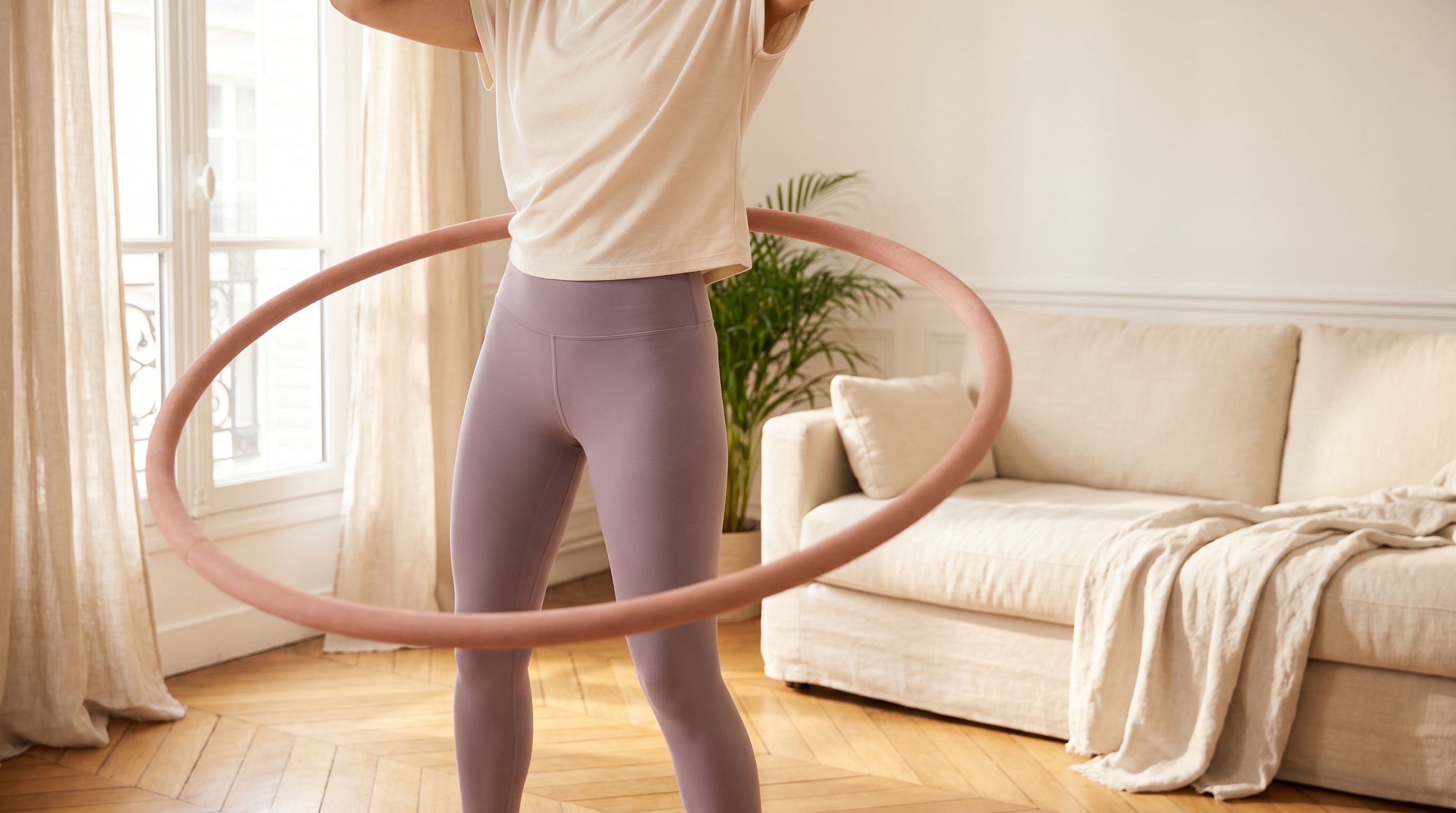 Recreation, not exercise — femme avec un hula hoop dans un intérieur lumineux